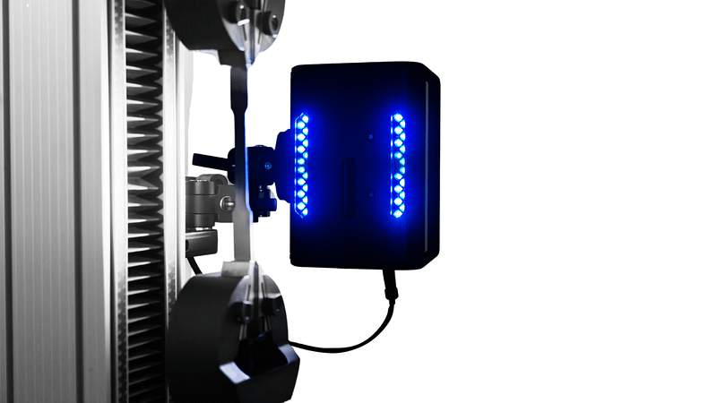 Close up of optical extensometer on UTM with metallic flat specimen