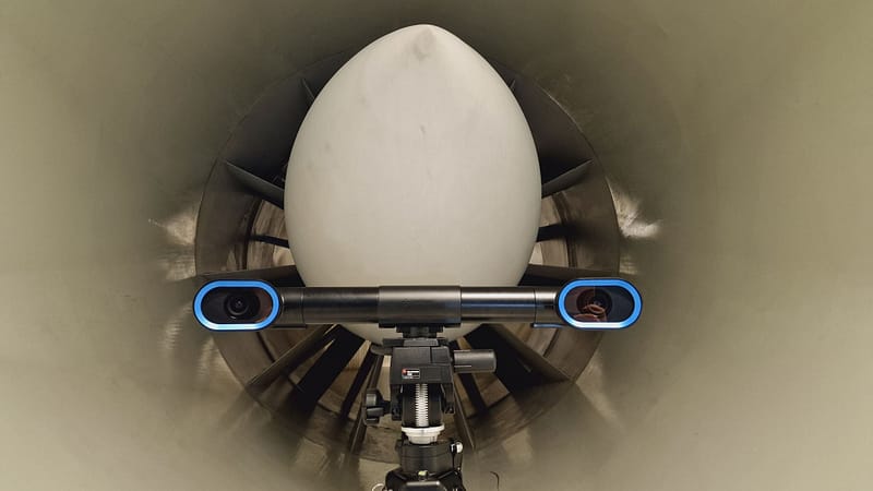 In this image you have MobiusWT, a 3d non-contact measurement solution for wind tunnel testing, in front of a wind tunnel